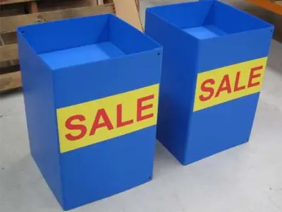 Open-top blue bins with a bright yellow SALE panel on the front