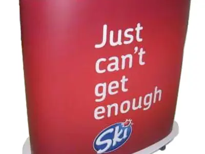 Red Ski counter on castors with a white top and 'Just can't get enough' wrap
