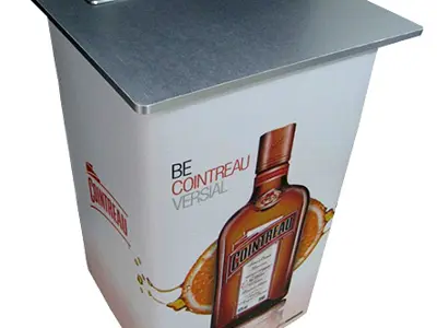 Cointreau bar table with a brushed metal top, recessed well and orange bottle graphics