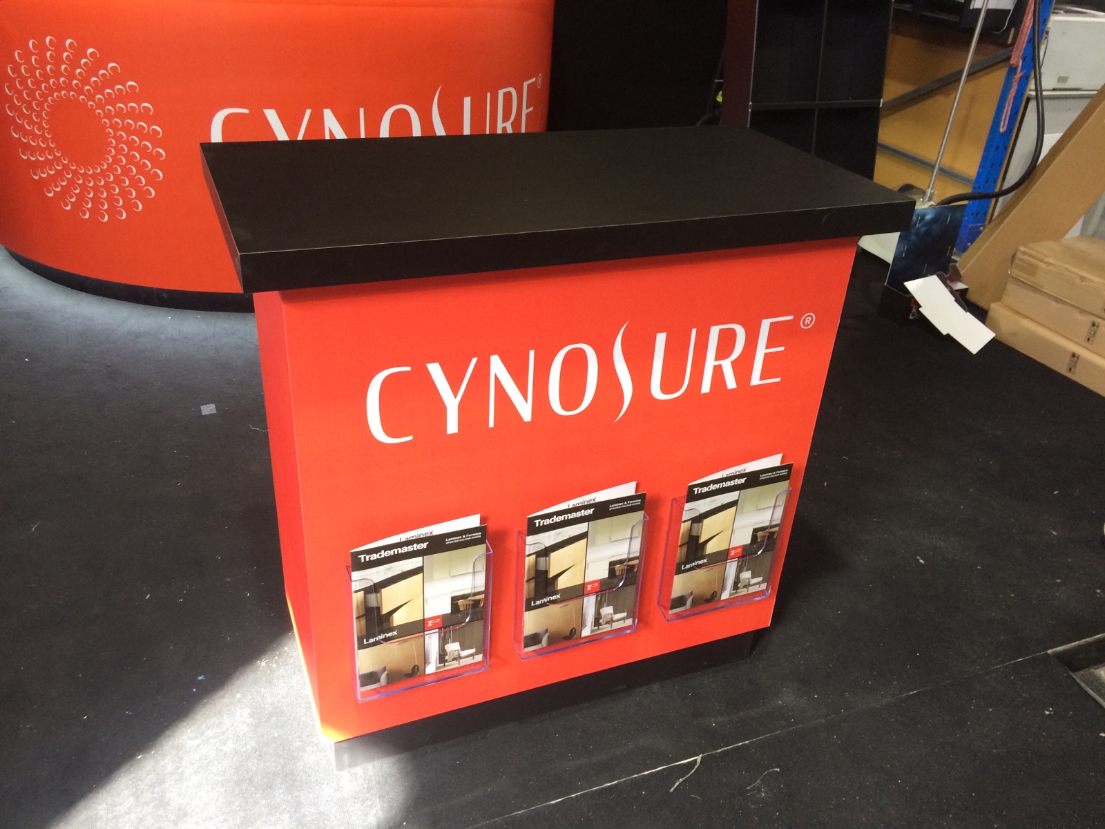 Orange Cynosure demonstration counter with brochure holders along the front