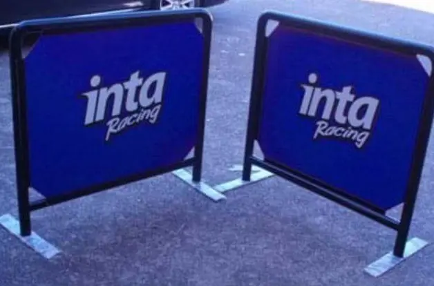 Black-framed inta Racing cafe barriers with blue printed panels on flat steel feet