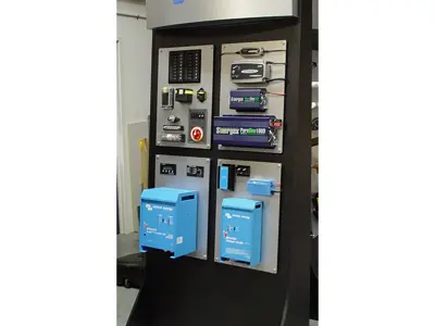 Victron Energy stand with electrical components on aluminium panels and two blue Phoenix chargers