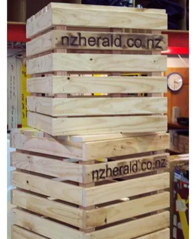Slatted timber crates with nzherald.co.nz burnt in, stacked into a tall column