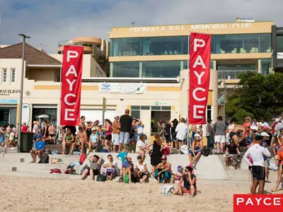 Red PAYCE flags rising above a crowd on steps outside Cronulla RSL Memorial Club