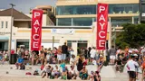 Sponsor flags above the crowd at a beach event