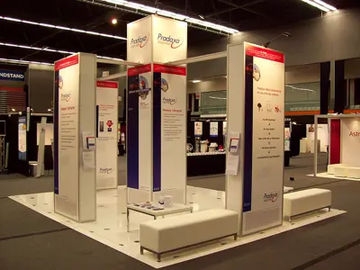 Pradaxa island stand on a raised floor with tall white towers and upholstered benches