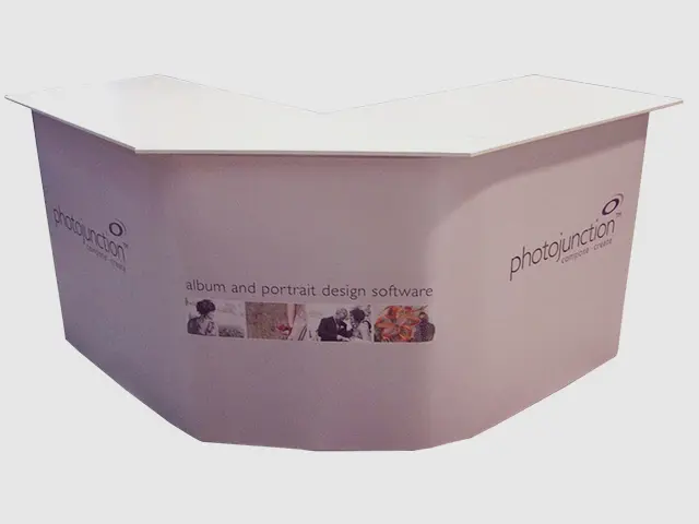 Angled white counter with Photojunction logos on both ends and sample images across the front