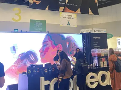 Tropeaka counter with 3D letters and smoothie samples in front of an LED screen wall