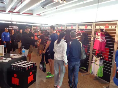 Official IRONMAN pop-up store with clothing on slatwall panels and branded tables in front