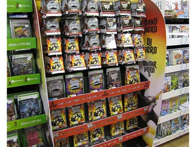 Guitar Hero 5 'Join the Music' stand with hanging packs above shelves of boxed games