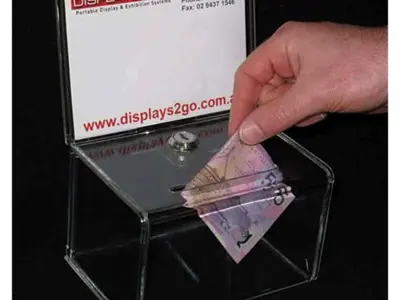 Banknote posted into a small perspex box with a key lock and upright sign holder