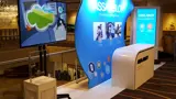 Curved exhibition display with counter and screen totem