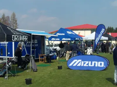 Mizuno gazebo, feather flag and low oval banner at a golf equipment demo day