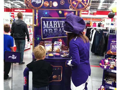 Costumed promoter at a round Cadbury Marvellous Creations counter under a tall cog-style header