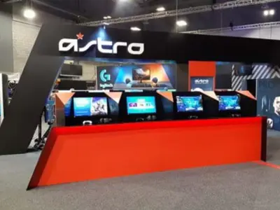 Astro stand with four hooded screen bays along a red counter under a white logo