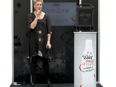 Curved black stage with a Diet Coca-Cola Style Zone back wall and bottle-printed round plinth
