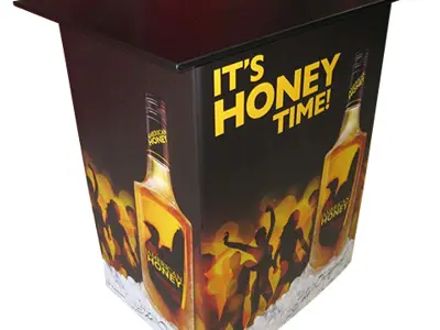 American Honey sales table with an 'It's Honey Time!' bottle wrap and dark top