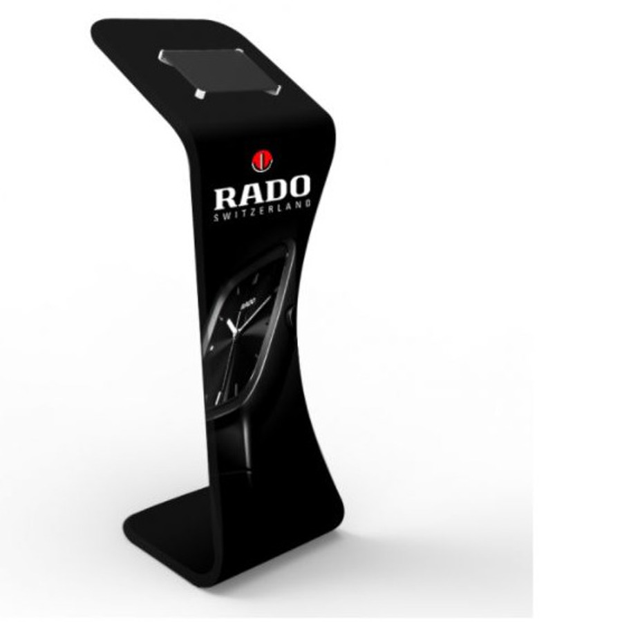 Free-standing tablet stand with a curved black body and a tablet holder at the top, printed with Rado Switzerland branding and a watch image