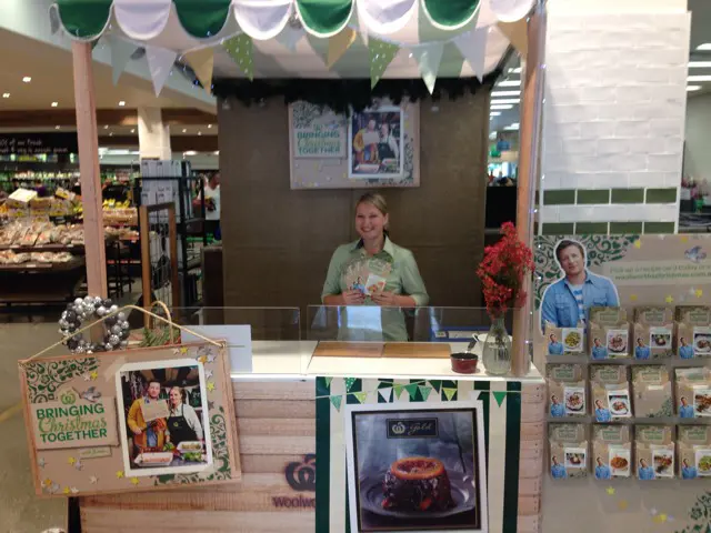 Woolworths 'Bringing Christmas Together' kiosk with a clear screen and Jamie Oliver recipe card rack