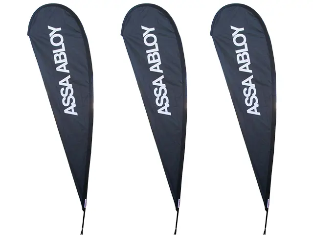 Three dark ASSA ABLOY teardrop flags with large white vertical lettering