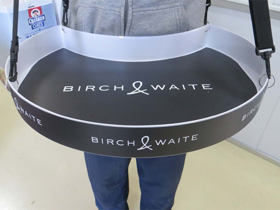 White tray with a black Birch & Waite graphic strip and printed base panel, worn on adjustable shoulder straps