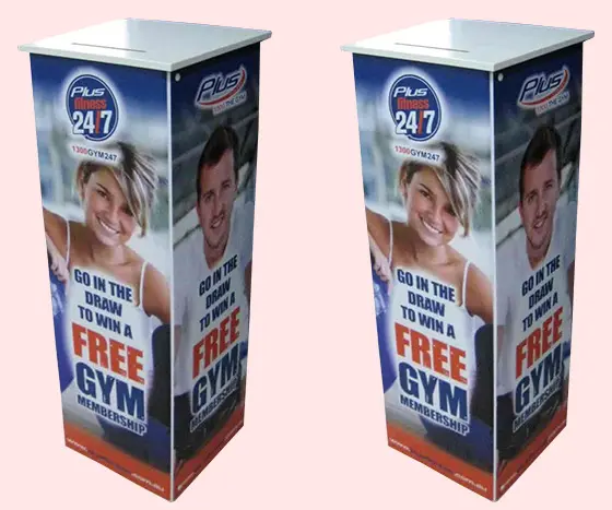 Plus Fitness 24/7 entry plinths with member portraits and a slot in the white top