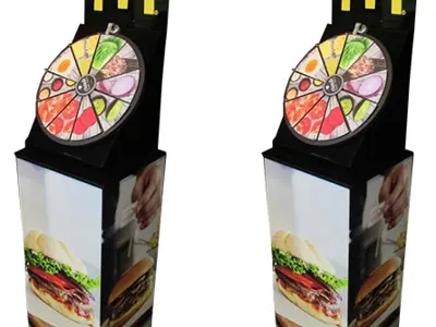 McDonald's burger wheel with ingredient segments under a golden arches header on a tall plinth