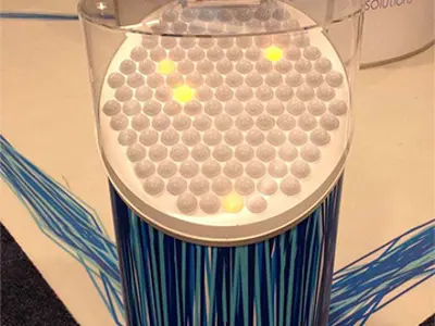 White spheres, some lit yellow, under a clear dome on the Coherent Solutions stand