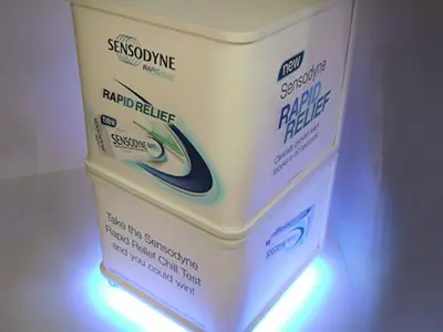 Sensodyne Rapid Relief cube wrapped in pack graphics, with blue lights around its base
