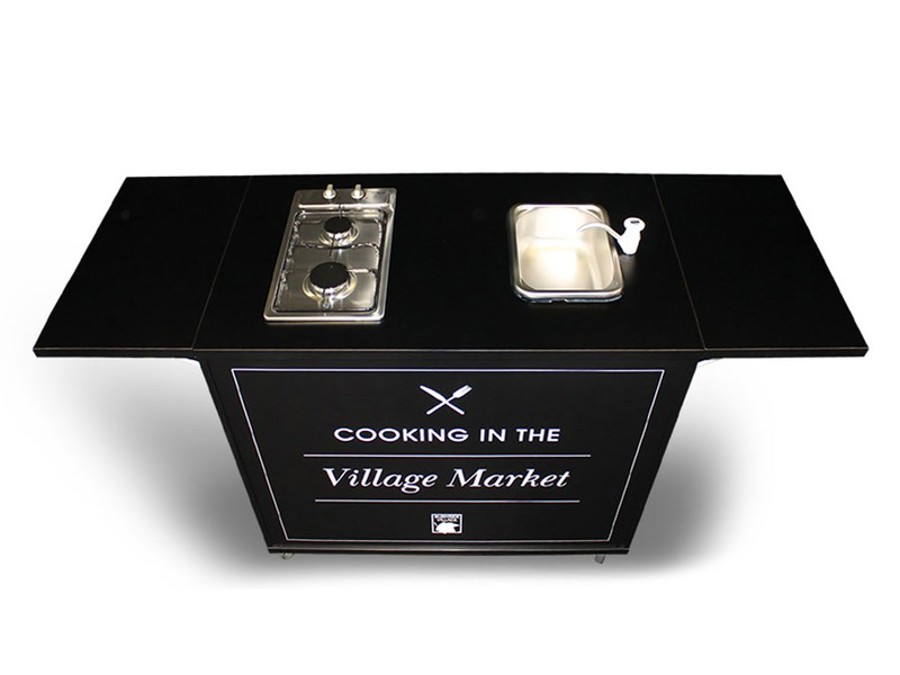 Top view of a black portable kitchen cart with a two-burner cooktop, a small stainless steel sink with tap and fold-out wings either side
