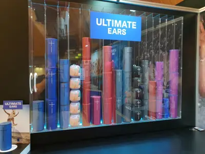 Ultimate Ears speakers stacked in colour columns like equaliser bars inside an acrylic case