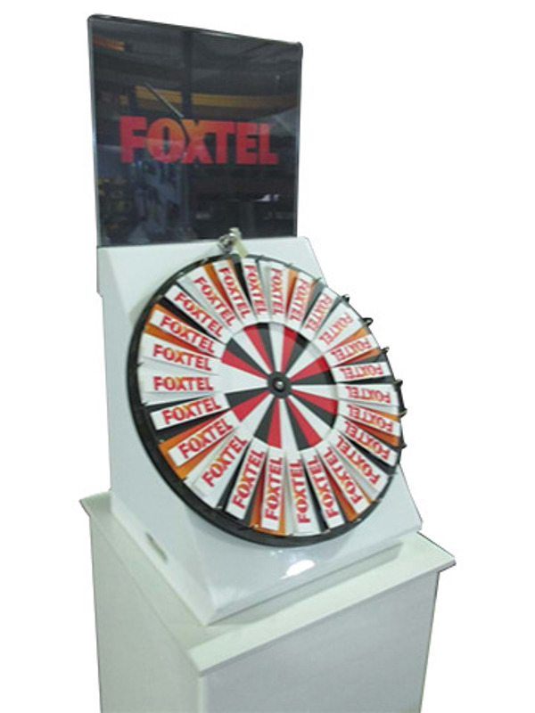 Prize wheel with removable Foxtel-branded segments on a white plinth with an acrylic header