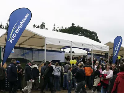 Blue PGG Wrightson teardrop flags at both ends of a long field day marquee
