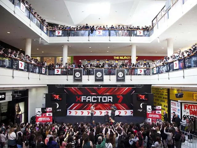Red X Factor stage set at Highpoint seen across a multi-level shopping centre atrium