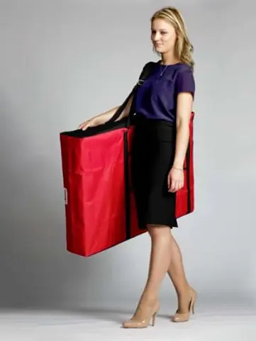 Slim red padded carry bag with a shoulder strap holding a portable demo table