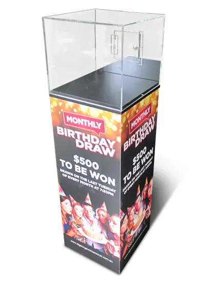 Clear Monthly Birthday Draw box on a plinth wrapped in party imagery and draw details
