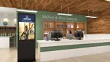 Lobby kiosk with portrait screen beside a reception desk