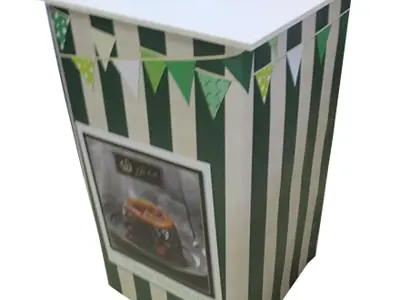 Green and white striped counter with bunting and a framed food photo on the front