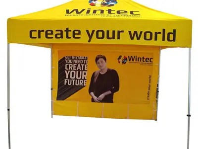 Bright yellow Wintec gazebo with a student portrait printed on the back wall