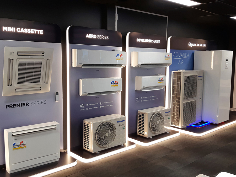 Air conditioner showroom with illuminated branded bays showing wall-mounted, ceiling cassette and outdoor units on lit bases