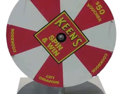 Keen's Spin & Win wheel with red prize segments on a round steel base