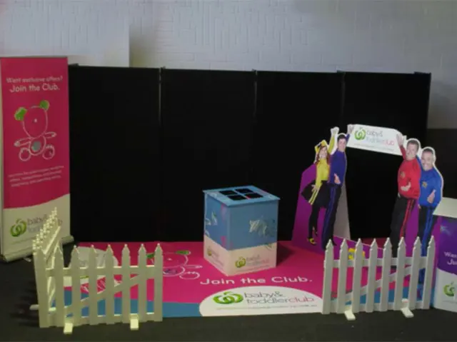 Pink Join the Club floor graphic inside a white picket fence with Wiggles cut-outs