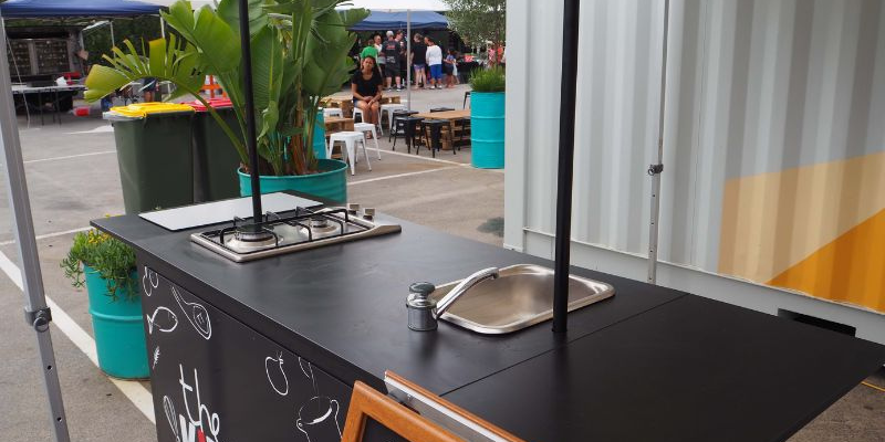 Cooking demonstration bench with induction hob and sink in the market food court