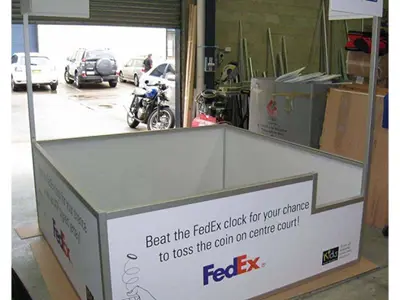 FedEx tennis game enclosure with beat-the-clock side panels and FedEx and ATP header signs