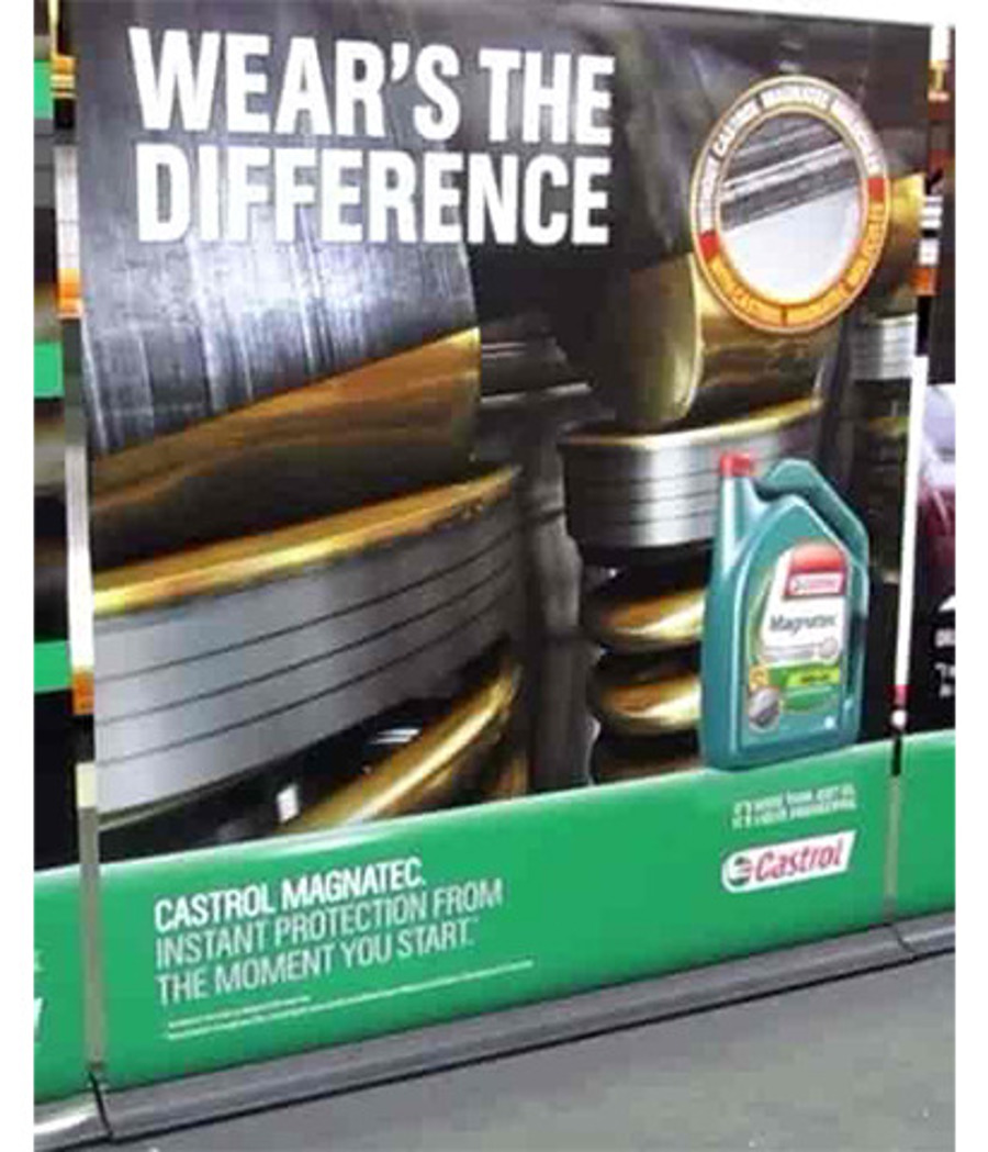 Printed Castrol Magnatec display wall with a large white sans serif headline on a dark photographic background and white text on a solid green panel