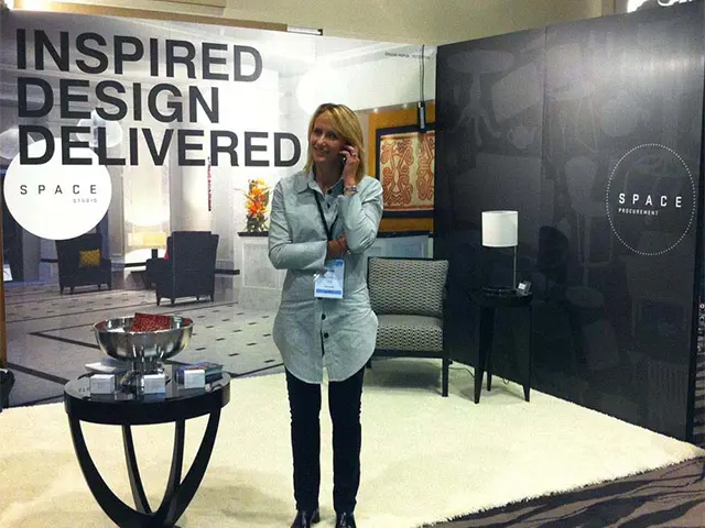 Space Procurement stand with an armchair, lamp and side tables on a white rug