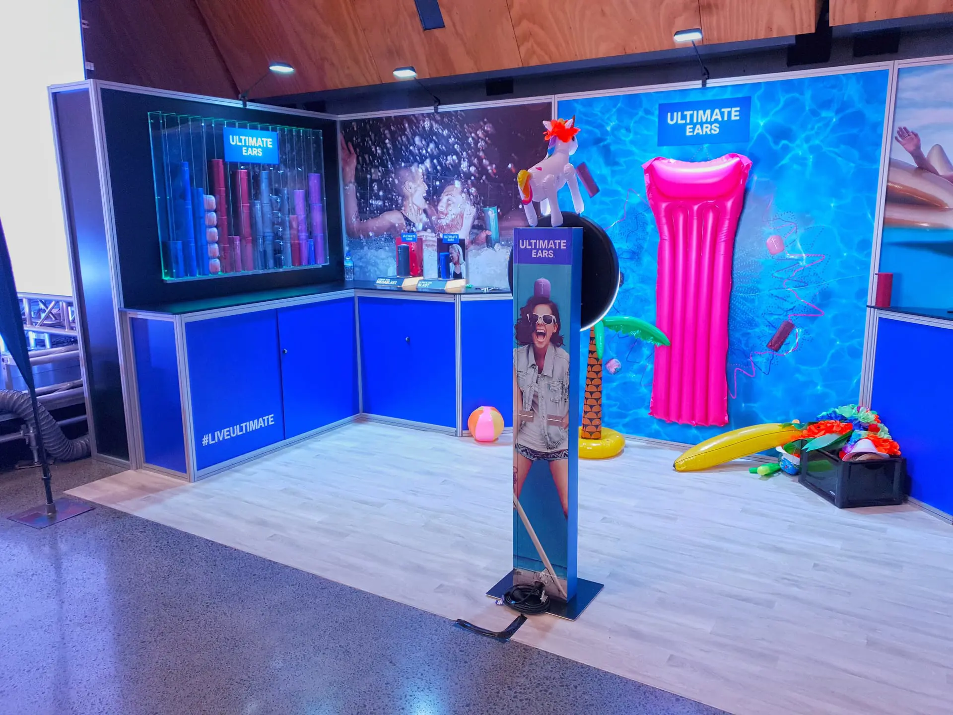 Ultimate Ears stand with a pink lilo, pool toys and a lit speaker showcase