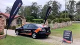 Teardrop flags and A-frame sign at an open home