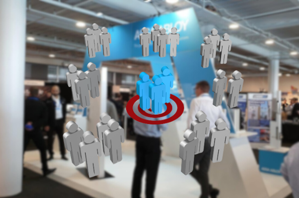 Grey figure icons around a group of blue figures standing on a red target, over a blurred trade show stand