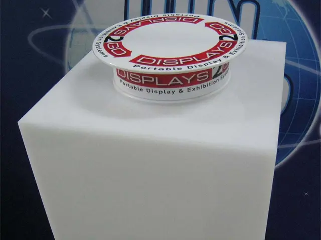 Round turntable on a white plinth with red and white logo branding around the rim